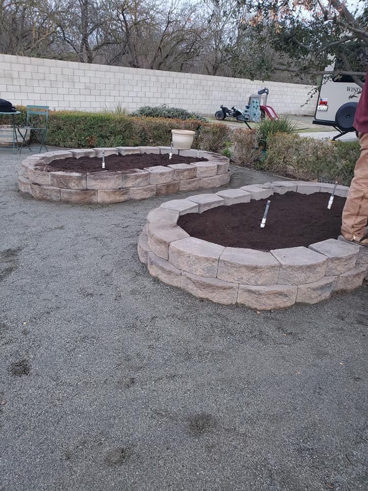 A man is standing next to a fire pit in a backyard.
