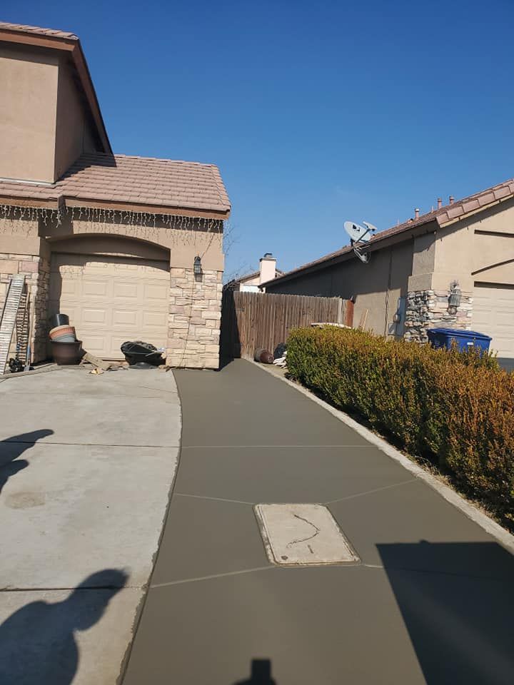 A concrete walkway leading to a house in a residential area.