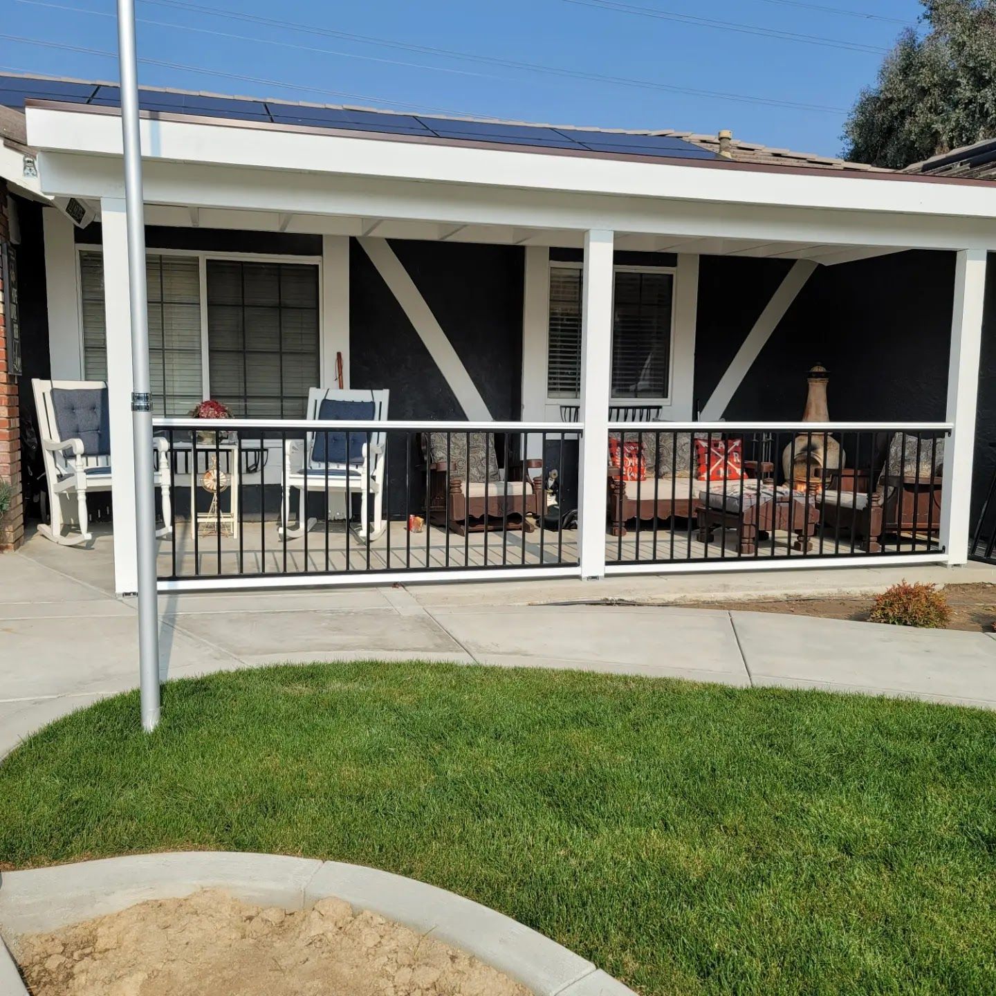A house with a covered porch with chairs and a table