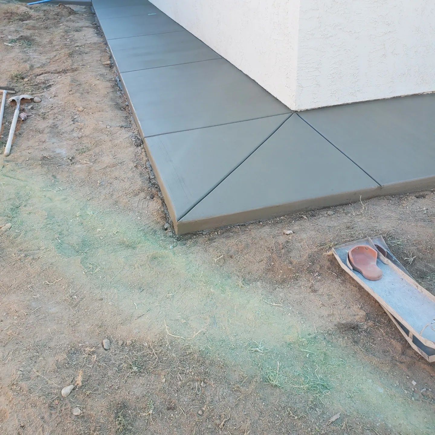 A concrete walkway is being built on the side of a building
