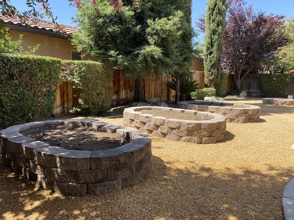 A row of fire pits in a backyard next to a house.
