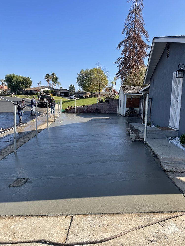 A concrete driveway is being built in front of a house.