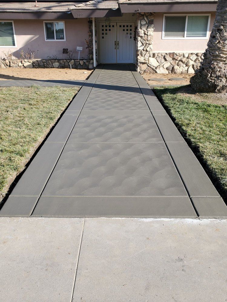 A concrete walkway leading to the front door of a house