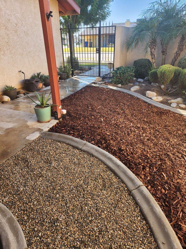 A gravel path leading to a house with a fence in the background