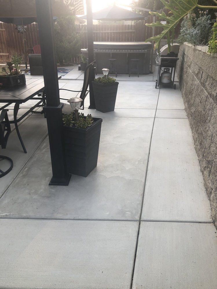 A patio with a table and chairs and potted plants