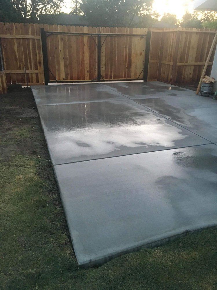 A concrete patio with a wooden fence in the background.
