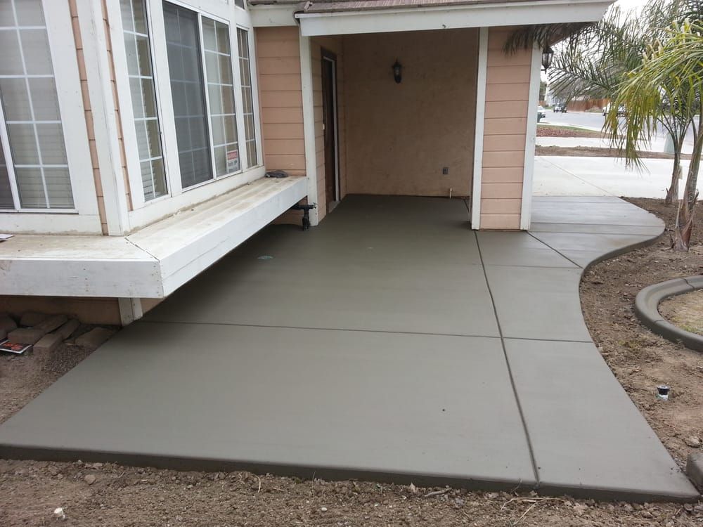 A concrete walkway is being built in front of a house.