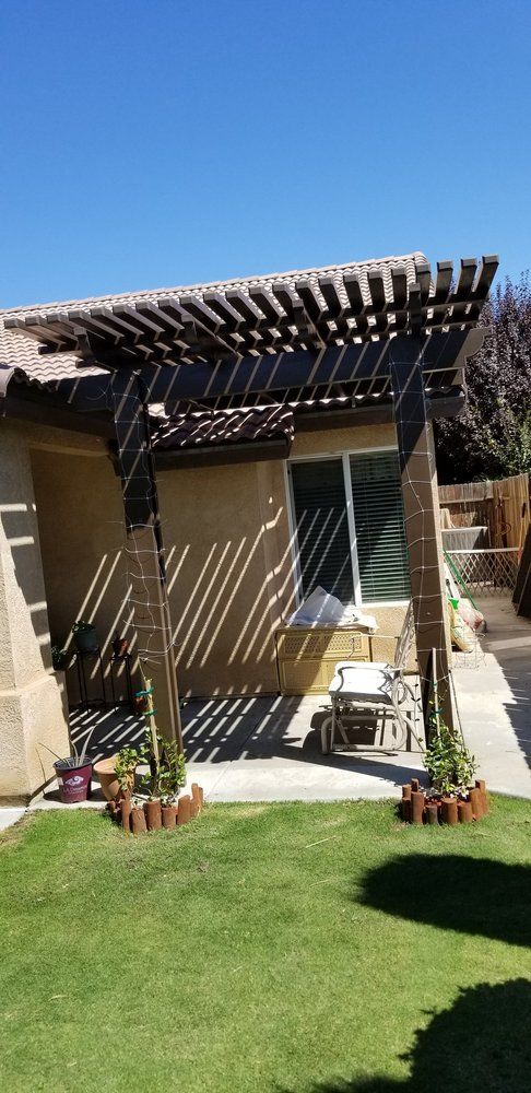 There is a pergola in the backyard of a house.