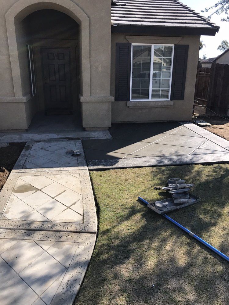 A concrete walkway is being built in front of a house.