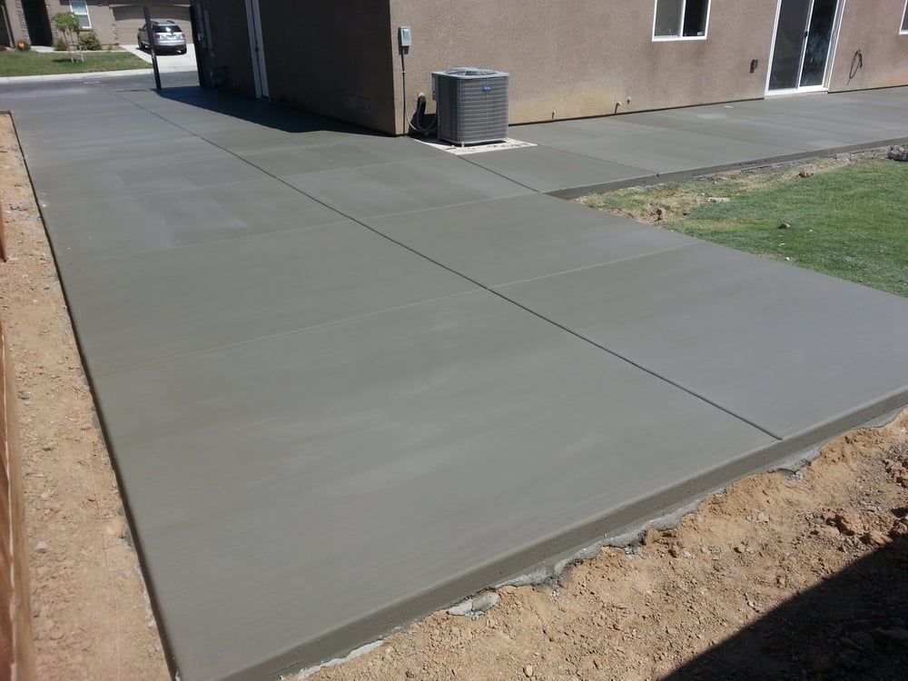 A concrete driveway is being built in front of a house.