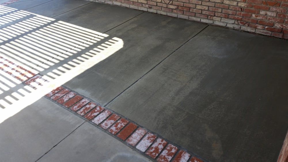 A brick wall is behind a concrete floor in a garage.
