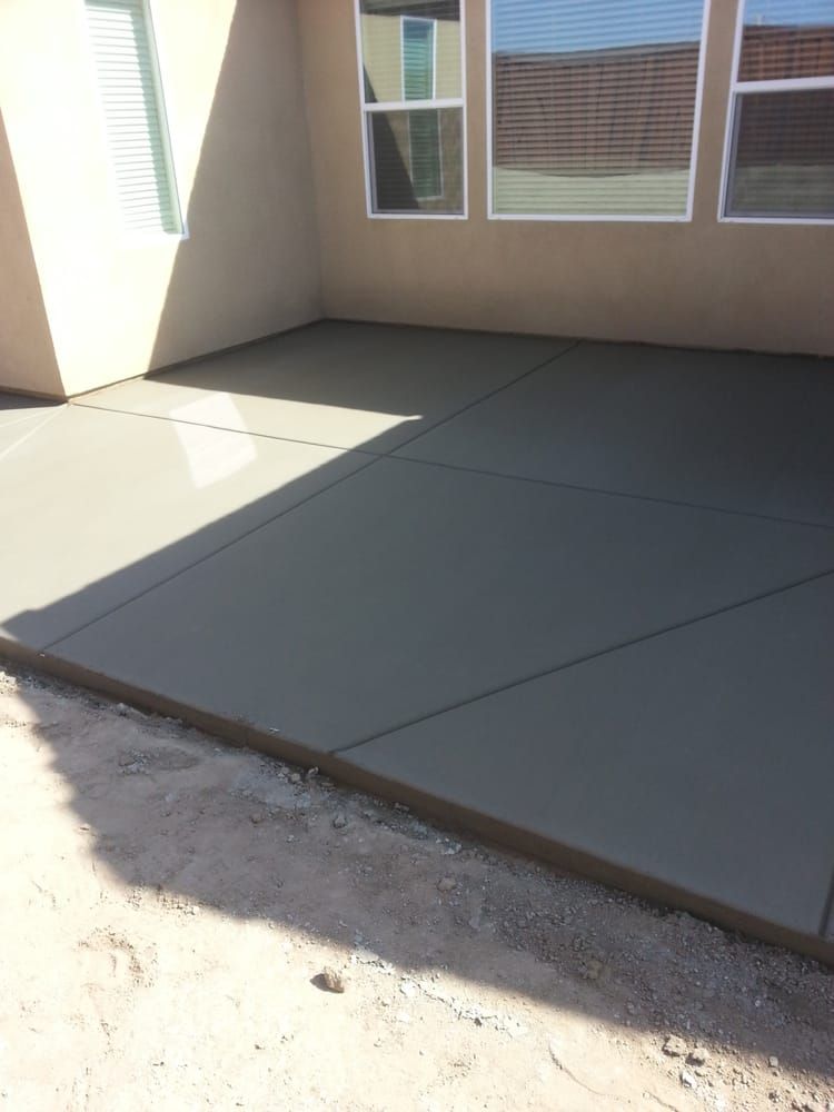 A concrete driveway in front of a house with windows