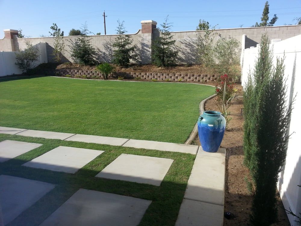 A lawn with a blue vase in the middle of it
