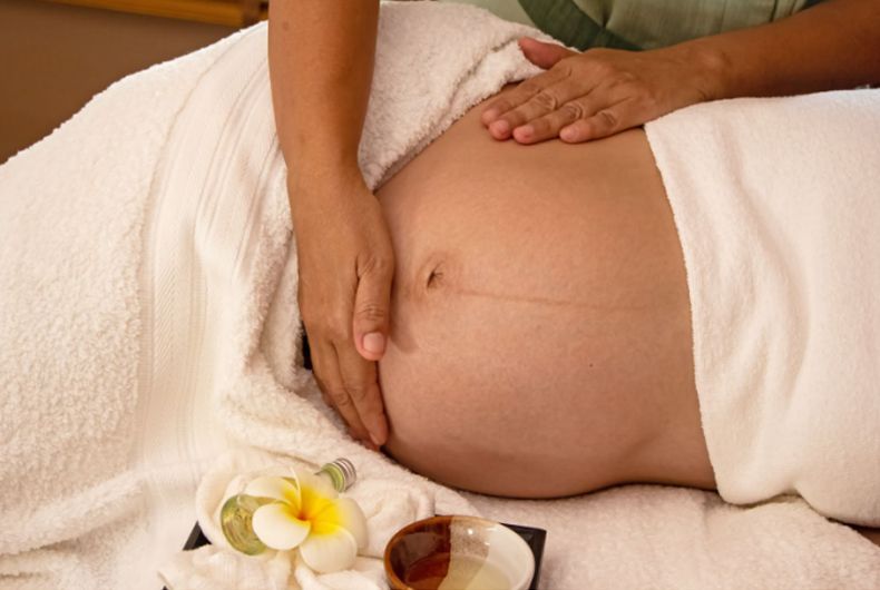 A pregnant woman is getting a massage at a spa.