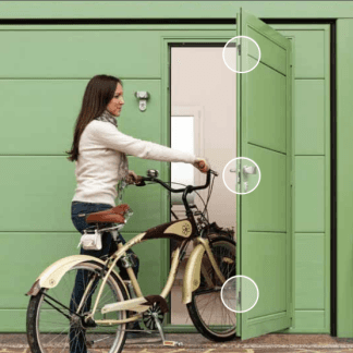 una donna con una bici che entra in una porta verde