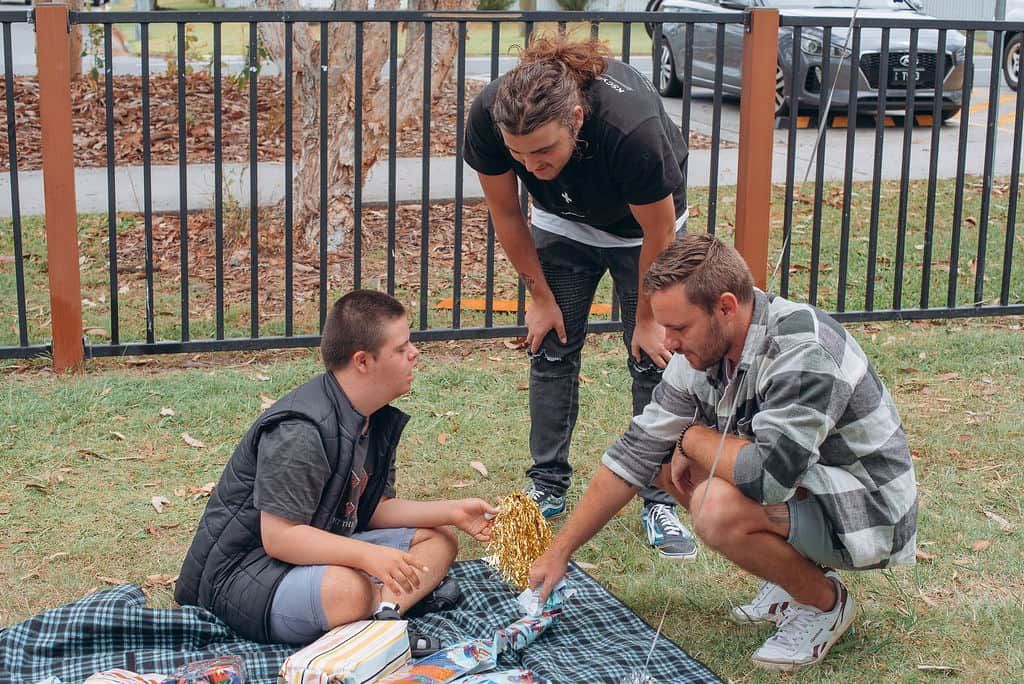 A Group Of Men Are Having A Picnic In The Park — Tailored Support Services Pty Ltd In Maroochydore, QLD