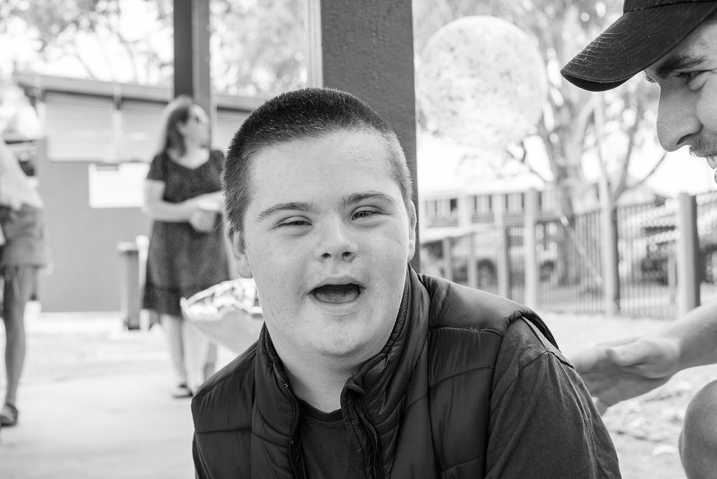 A Black And White Photo Of A Young Boy Smiling — Tailored Support Services Pty Ltd In Maroochydore, QLD