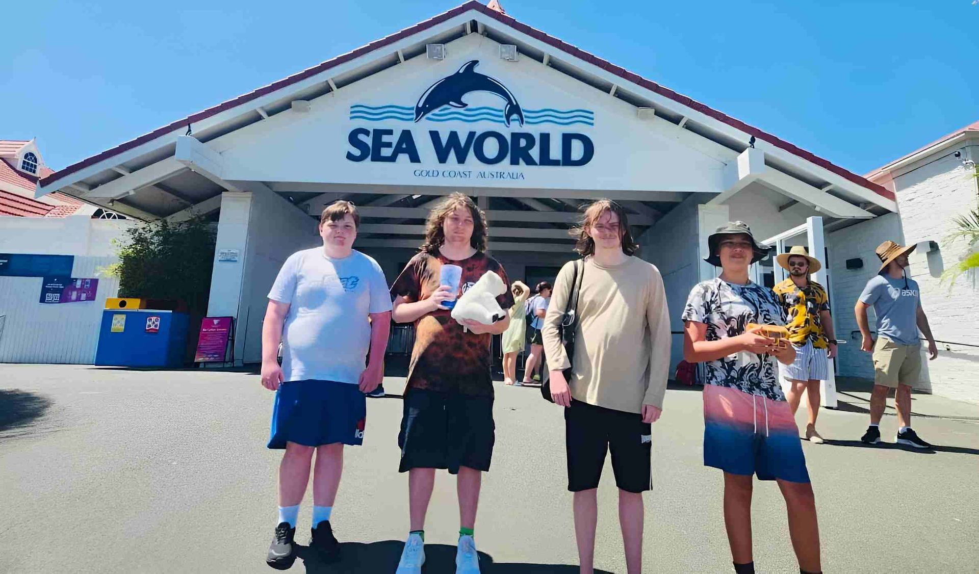 A Group Of People Are Standing In Front Of A Sea World Building — Tailored Support Services Pty Ltd In Maroochydore, QLD