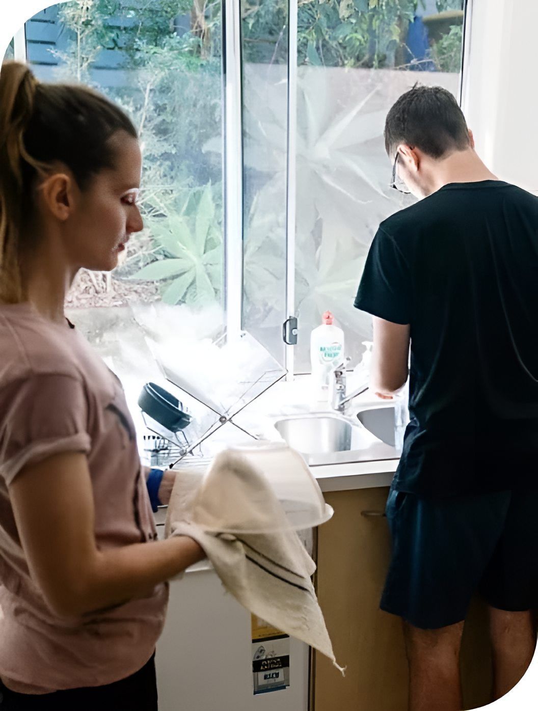 A Man And A Woman Are Washing Dishes In A Kitchen — Tailored Support Services Pty Ltd
 In Buderim, QLD