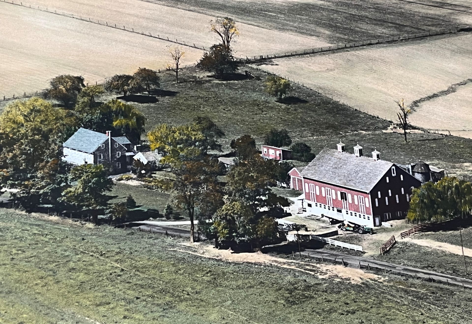 An aerial view of a farm with a red barn