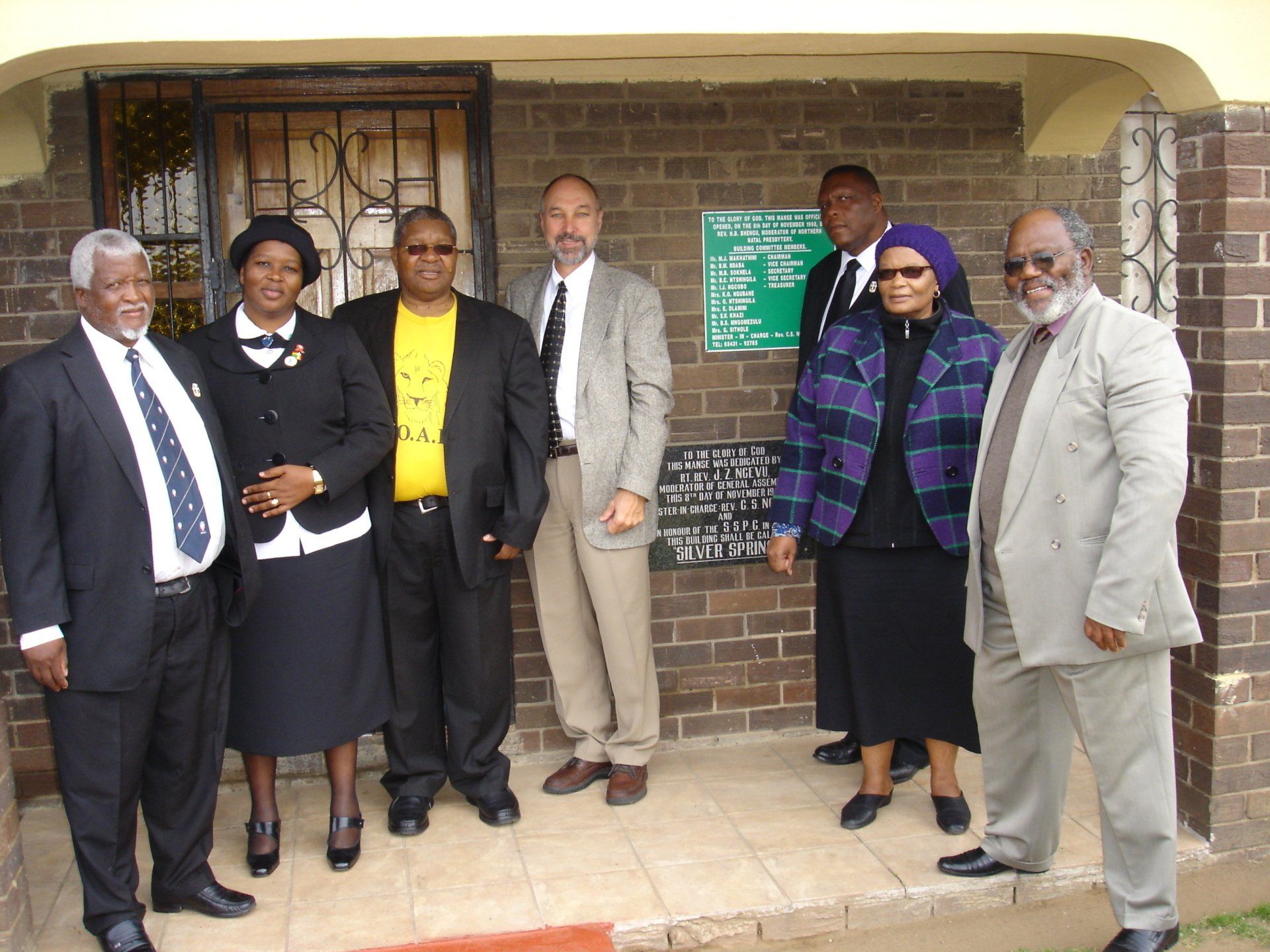 A group of people standing in front of a brick building