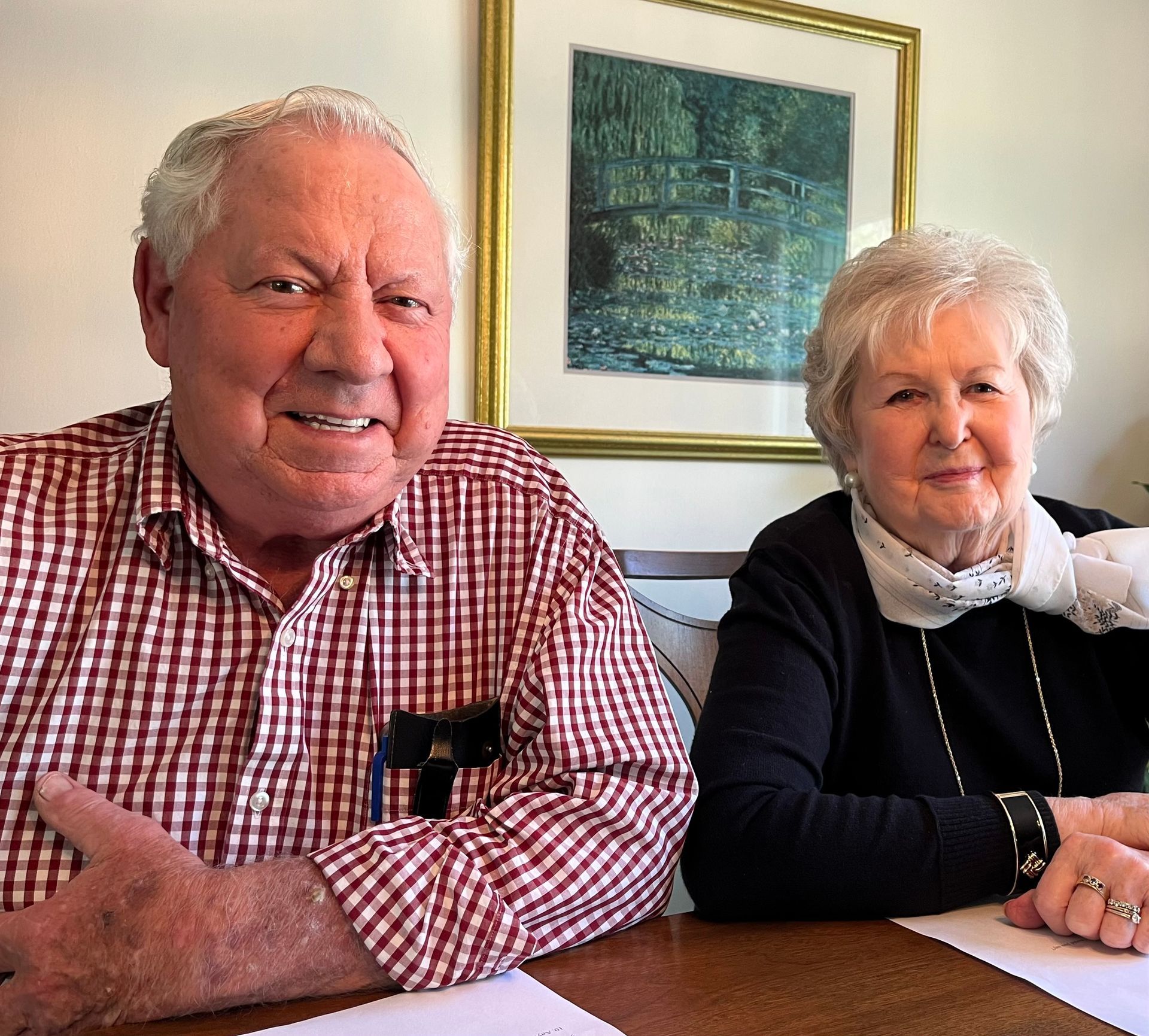 A man in a plaid shirt sits next to a woman in a black sweater