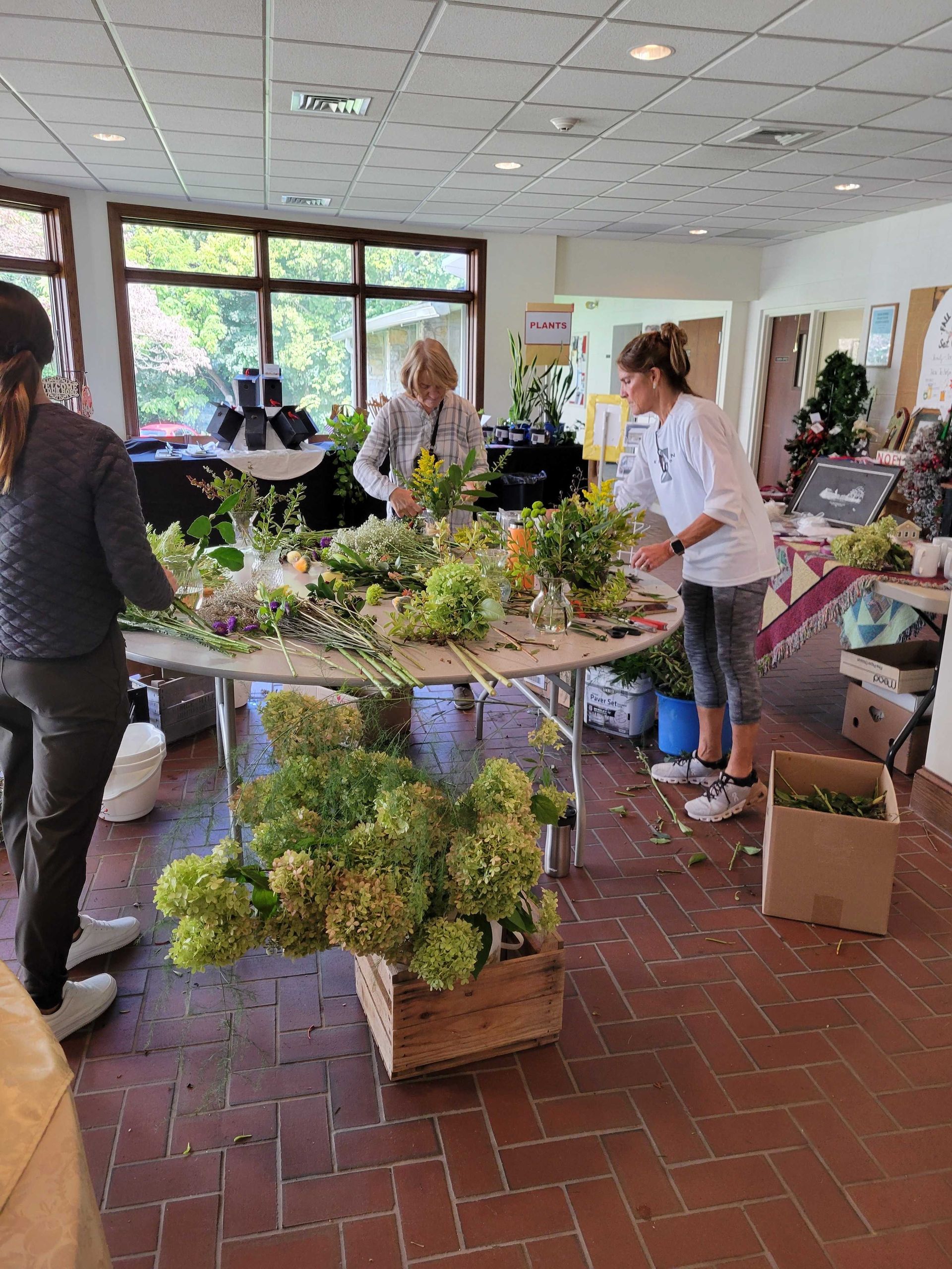 People arranging flowers at a workshop. Colorful blooms on a table.