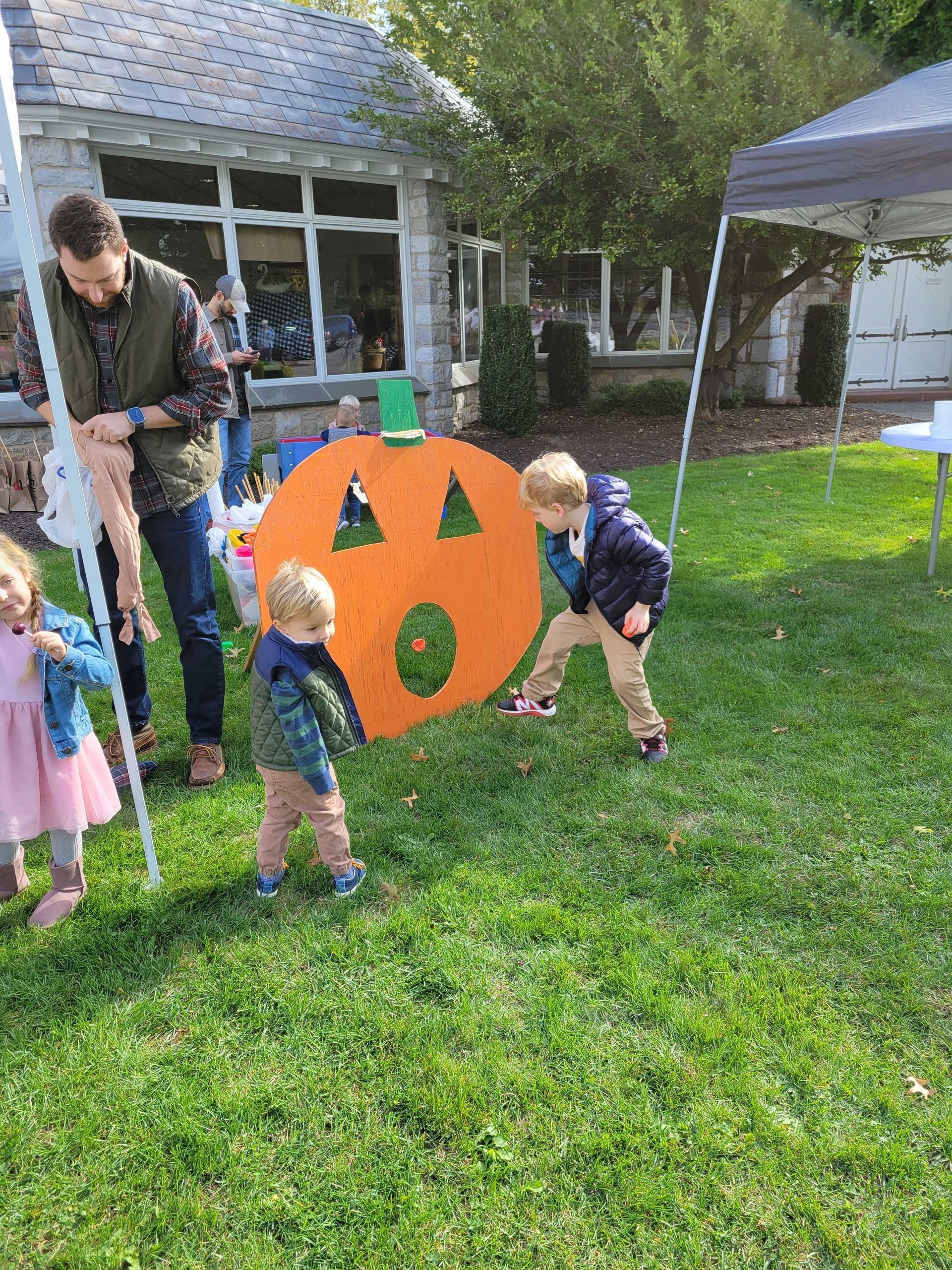 Children outside playing with pumpkin