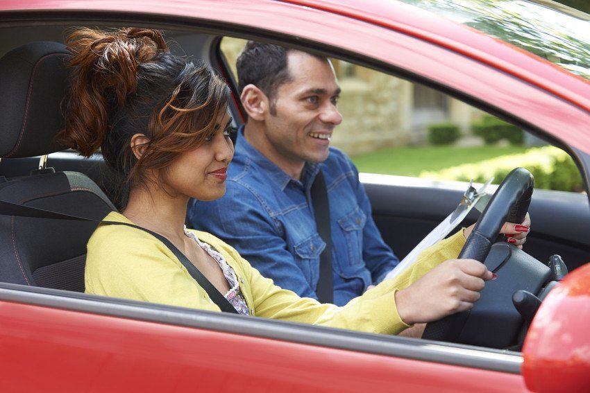 Young Woman Having Driving Lesson With Instructor