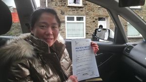 smiling lady holding pass for driving test