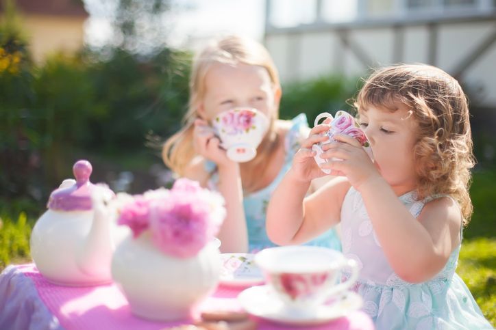 Two sisters playing tea party outdoors