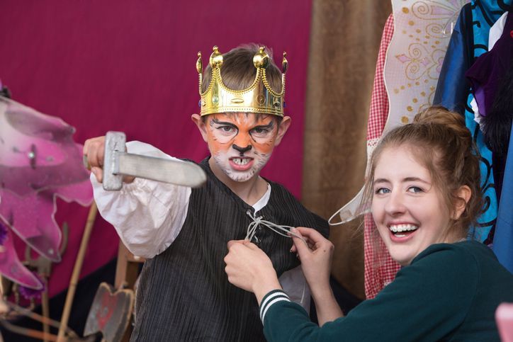 Child actor dressed as king wearing crown