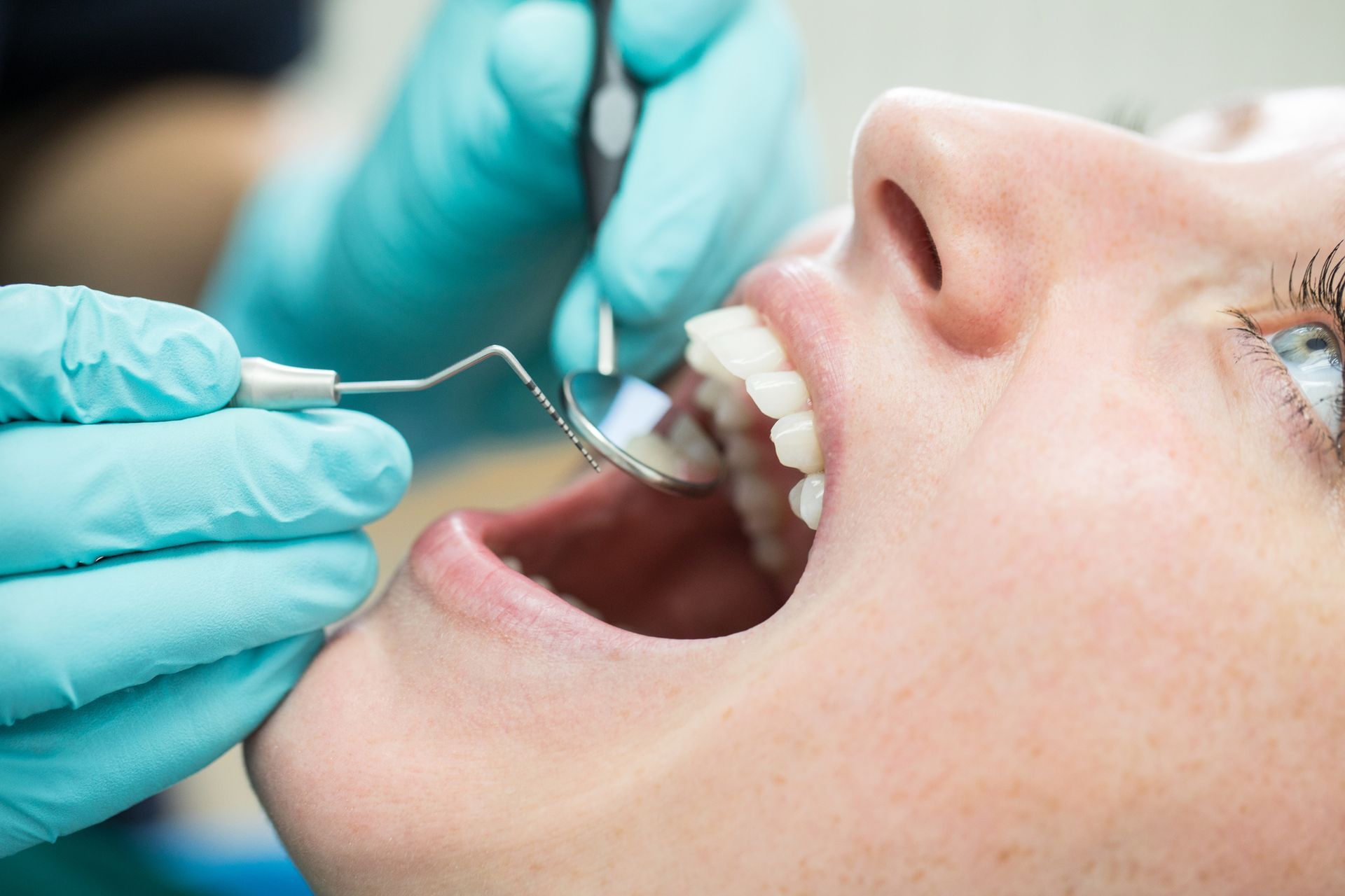 A woman is getting her teeth examined by a dentist.