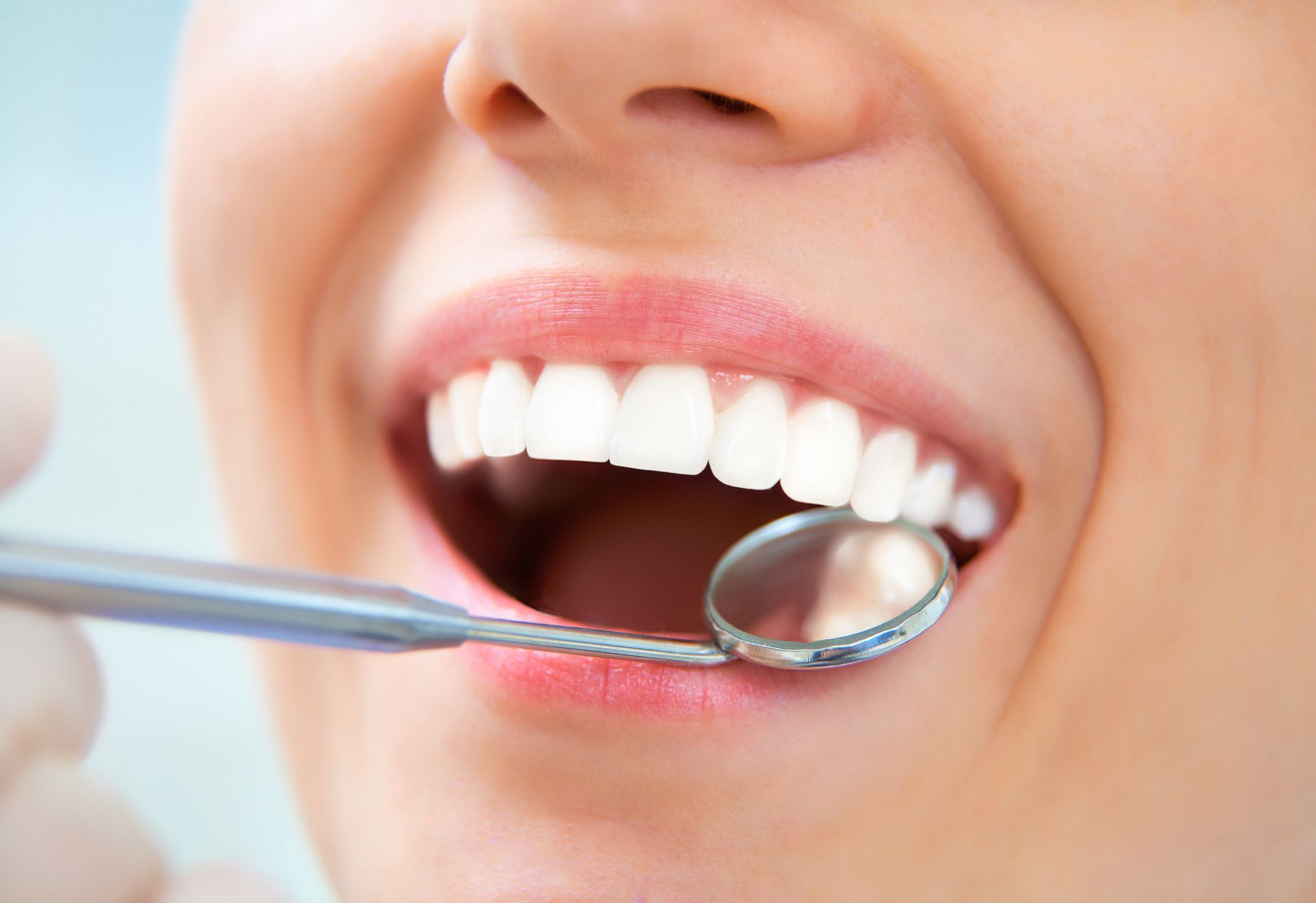 A woman is getting her teeth examined by a dentist.