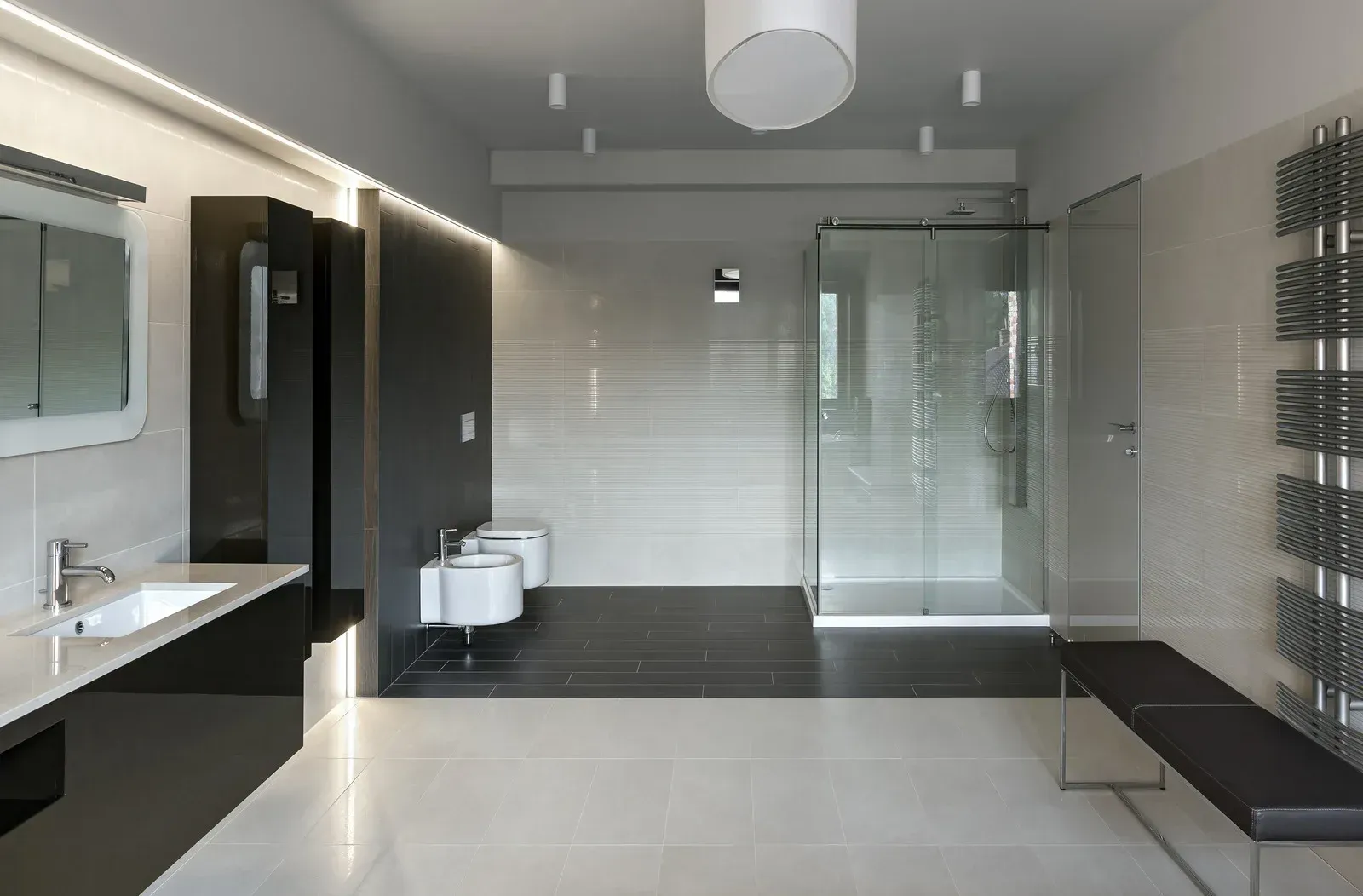 Modern bathroom with a glass shower, white fixtures, and dark accents.