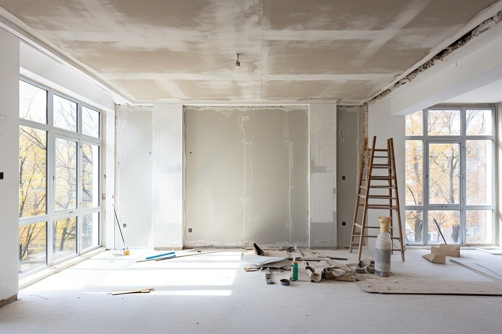 An empty room with a ladder and a lot of windows under construction.