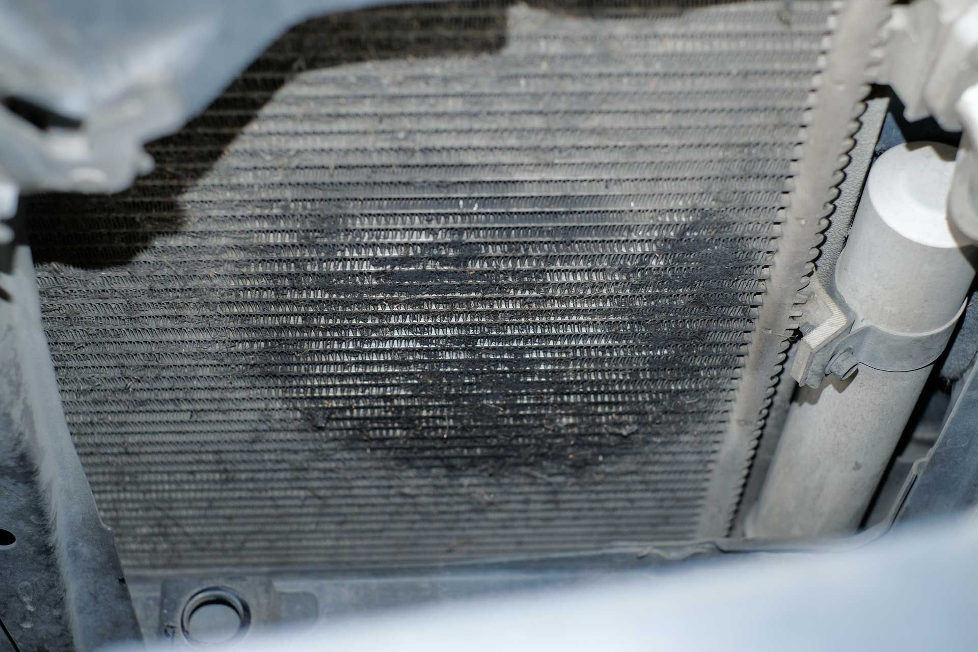 A close up of a dirty radiator on a car