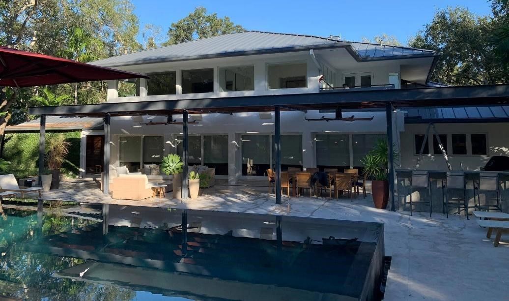 A large house with a swimming pool in front of it