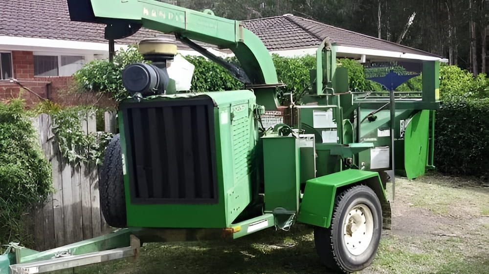 A Green Machine is Parked in Front of a House — Auz Tree in Hallidays Point, NSW