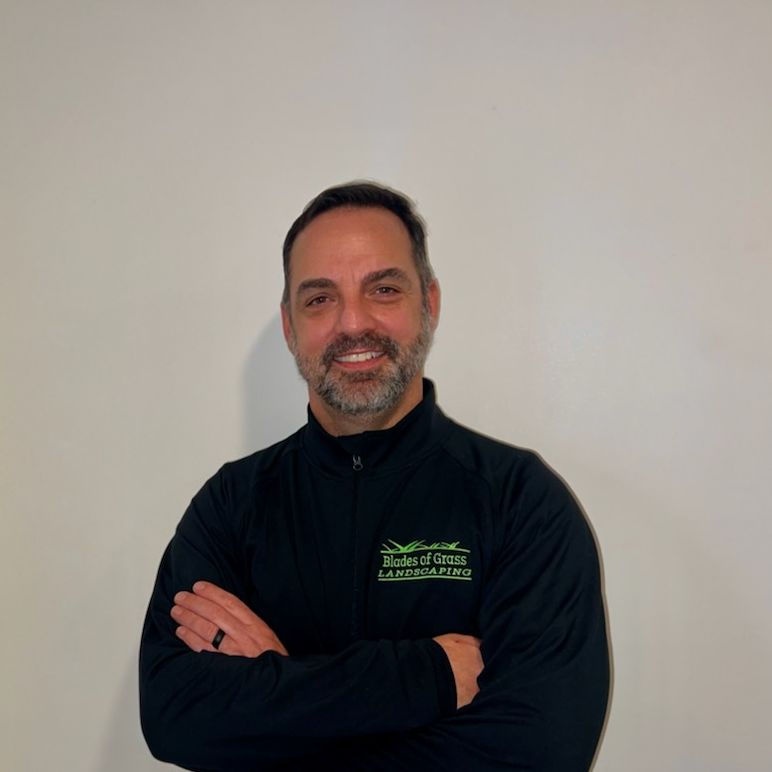 A man with a beard wearing a black jacket with a green logo on it