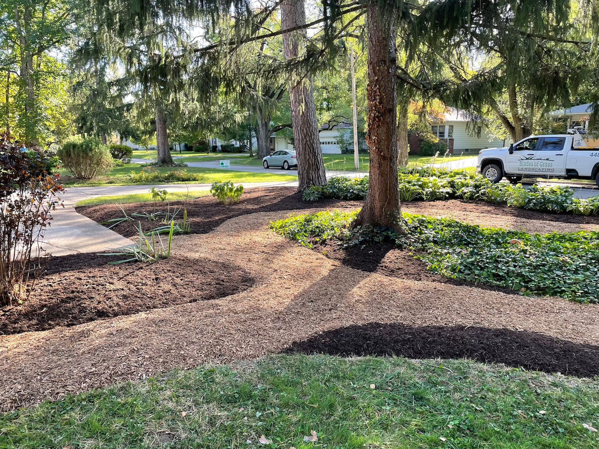 A white truck is parked in the middle of a lush green park.