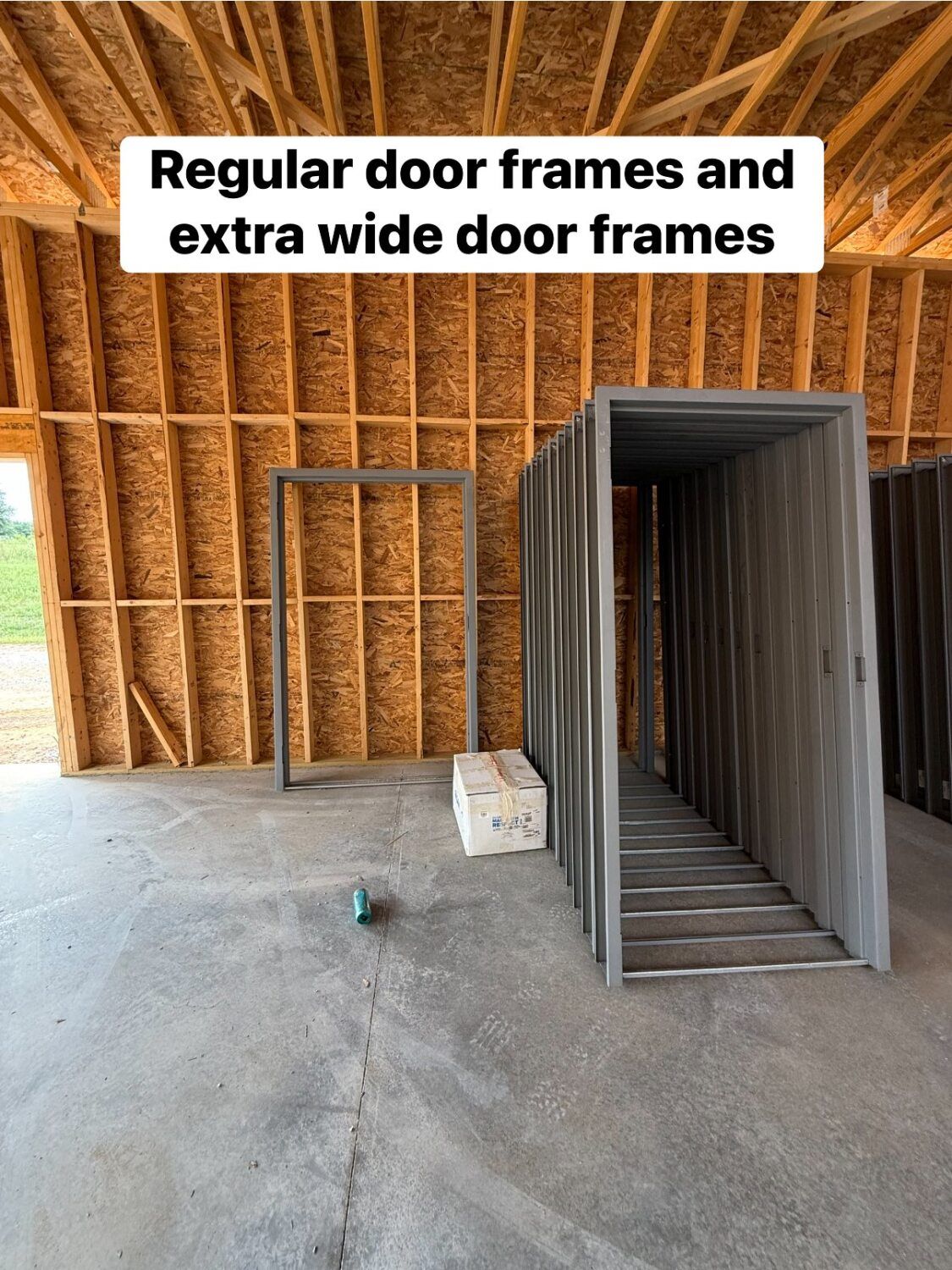 Door frames: regular and extra wide, inside a building under construction, walls of wood panels.