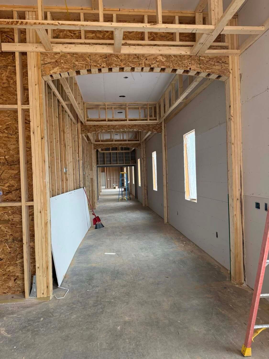 Interior of a building under construction, showing a hallway framed with wood.