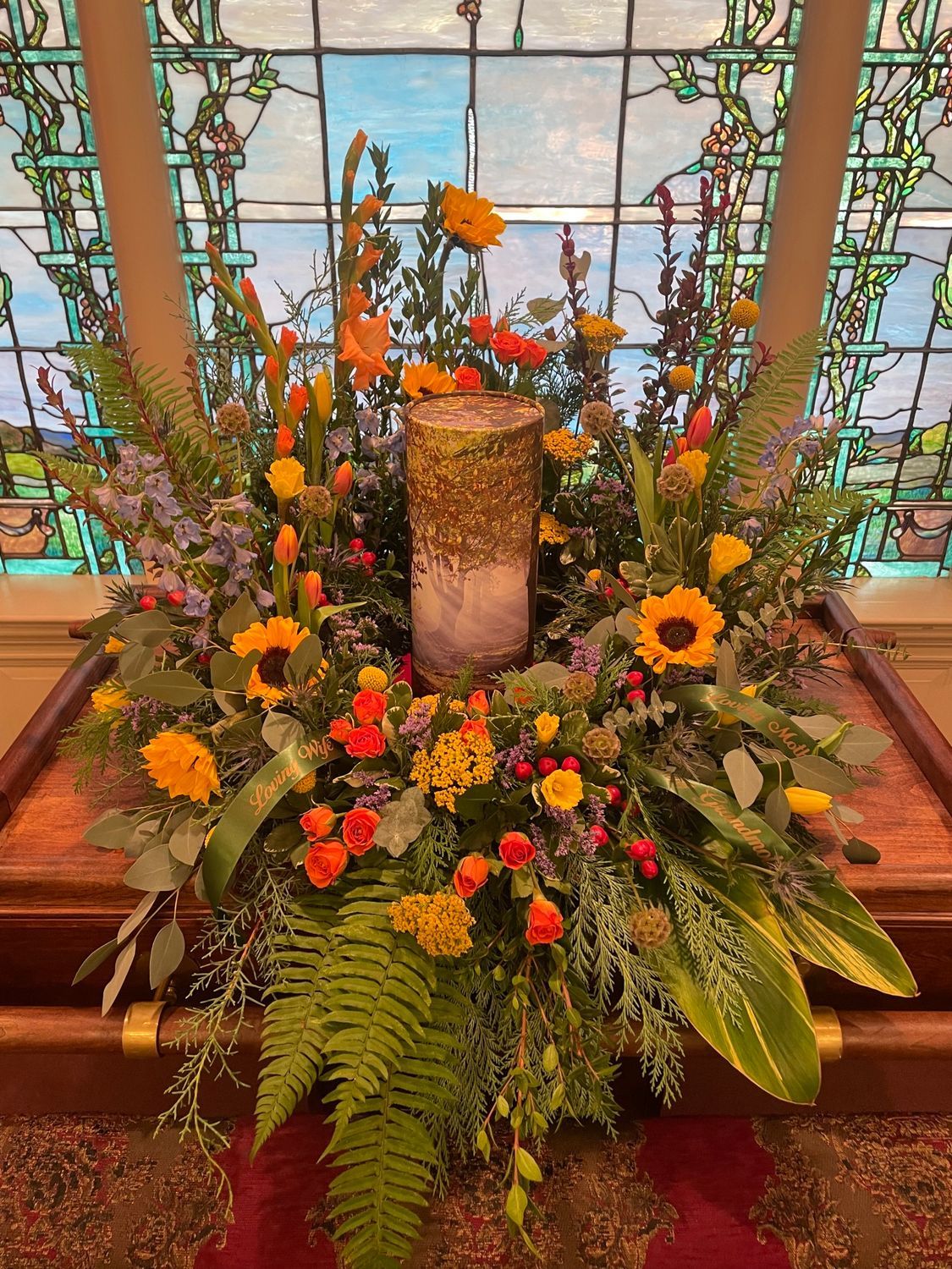 A wooden coffin with flowers on top of it in a church.