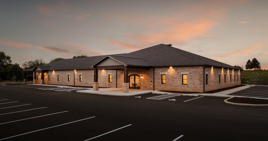 Modern funeral home exterior featuring accessible parking and welcoming contemporary architecture