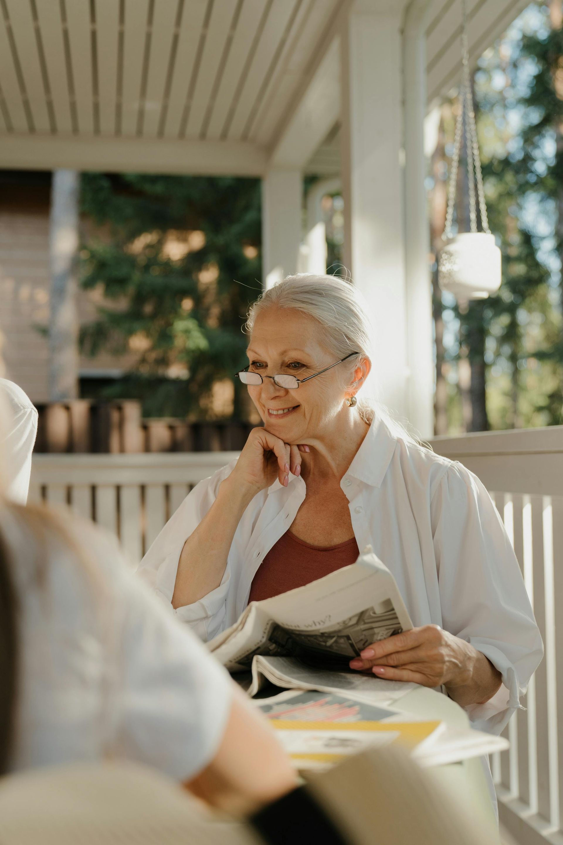 A young man is sitting at a table with his hands on his forehead.