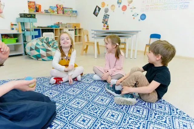 A group of children are sitting on the floor in a circle.