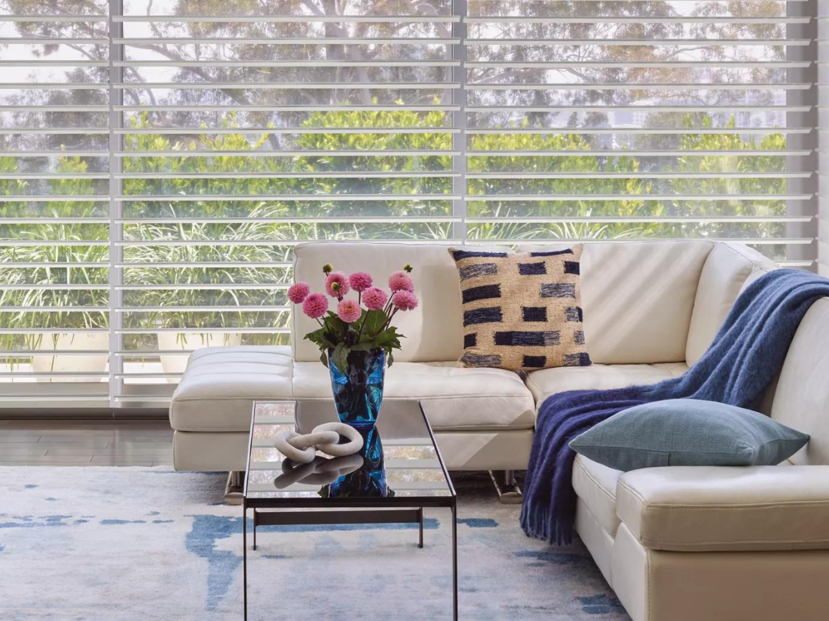 A living room with a couch and a coffee table with a vase of flowers on it in front of Hunter Douglas Shades. Interior Design  Decorating Custom Made Window Treatments Blinds
Shades Shutters Curtains Wallpaper Bedding Lamps Artwork Mirrors
Hunter Douglas Thibaut Trends Fabricut Carole Texas Paris Rods
Motorized powerview cordless top down / bottom up 
Wood Blinds Vignette Silhouettes Duettes Designer Screen Shades 
Fairfield Furniture Crestview Uttermost New Construction Renovations Builders
Interior Fancies Savannah House Grauers Phillips Interior Homes David’s Jackson’s
Martin’s Flooring Mods Blinds and Designs Graber Benjamin Moore Sherwin Williams
Garman Builders EG Stoltzfus Metzler Keystone Custom Homes Simeral Landmark
Bent Creek Country Club Lancaster County Country Club Highlands Tel Hai Garden Spot Village Willow Valley B&D Beacon Hill Scalamandre area rugs Anna French Sunbrella Pindler grass cloth Ralph Lauren Ron Redding Top Shelf Silk Linen Leather Velvet Range Rover Sport Mercedes Benz BMW Investment High End Luxury Ironstone Homes Main Line B&D Elite Turnberry European Builders Greth Grande Cedar Knoll Builders Rotelle Forest Ridge Builders Lexington Hoover Weaver
Lancaster Wyomissing Sinking Springs Lititz Akron Strasburg Manheim Hershey Ephrata Denver Adamstown Honeybrook Elverson Morgantown Exton Chester Springs West Chester Wernersville Mohnton Millersville Willow Street Kennet Square Thorndale Brandywine Paoli Malvern Newtown Square Media Radner Ardmore Devon Berwyn Hummelstown 
