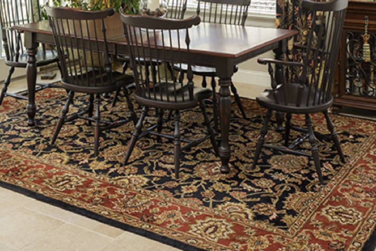 A dining room decorated with a table and chairs on a rug