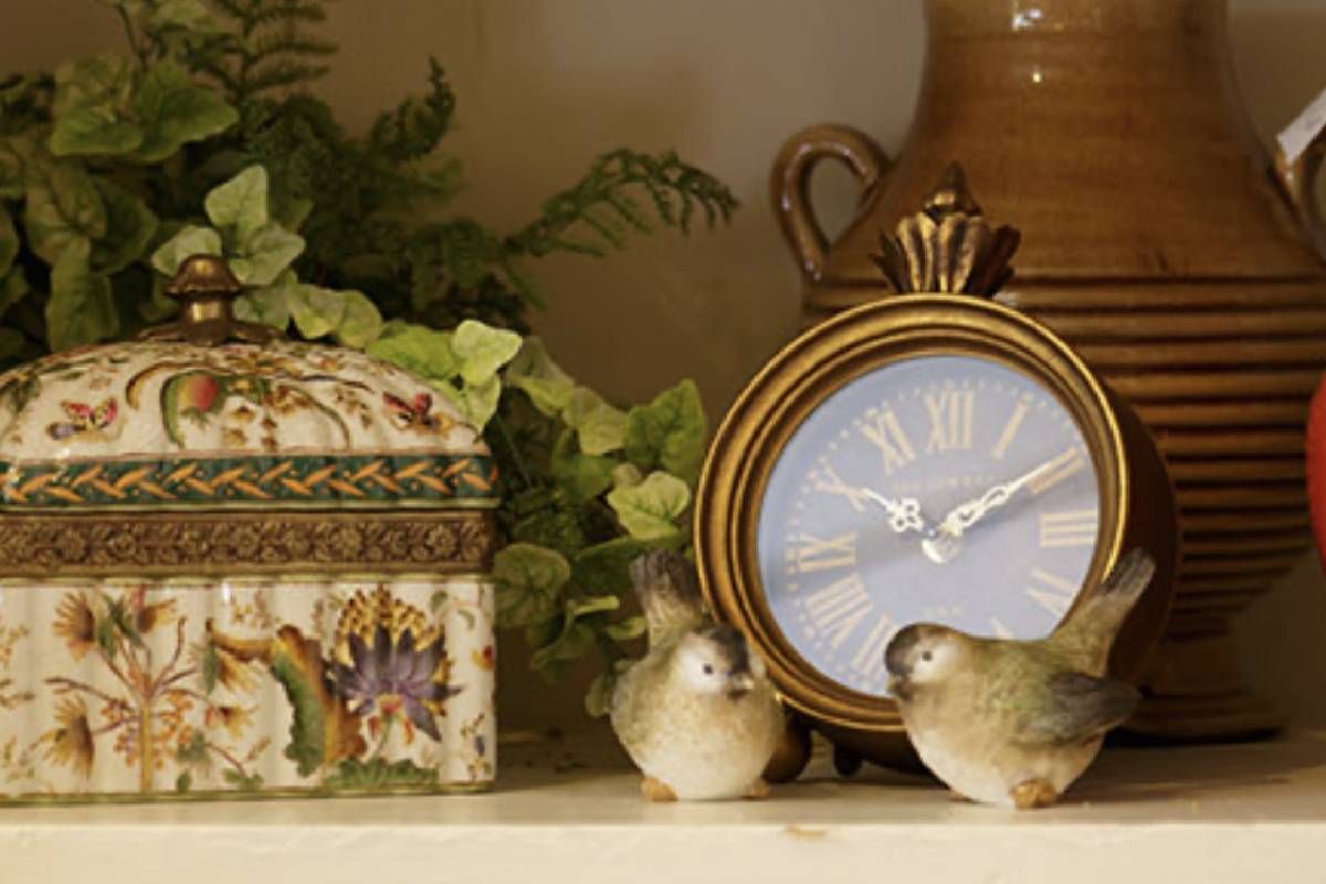 Home Decorations of clock with roman numerals is on a shelf next to two birds